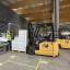 Cat Electric Forklift driver unloading crates onto conveyor belt